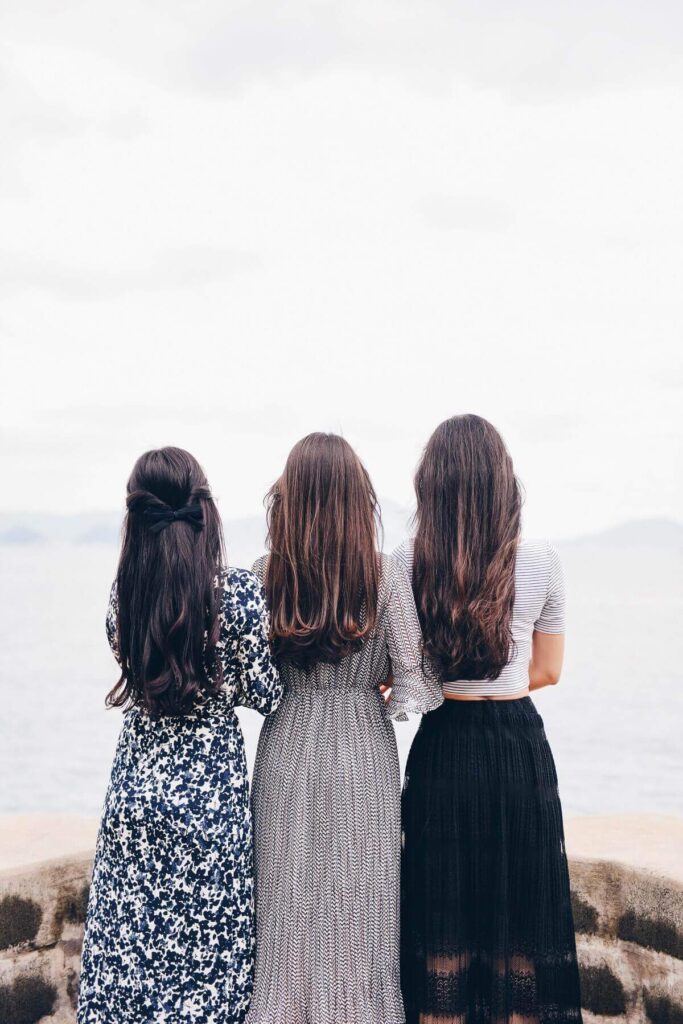 Tre ragazze di schiena a rappresentare Maria Adriana e le sue due sorelle