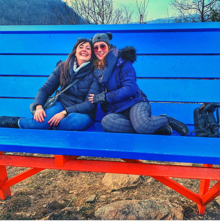 Cristina Bertolino con Susanna Lombardo sedute sopra Panchina Gigante Rore Sampeyre n. 52