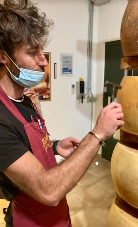 Marco Giolito batte col martelletto sulla forma di Parmiagiano Reggiano