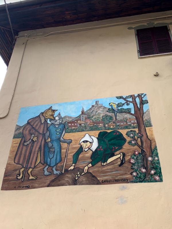 murales a Vernante di Pinocchio che semina i soldi su consiglio del Gatto e della Volpe